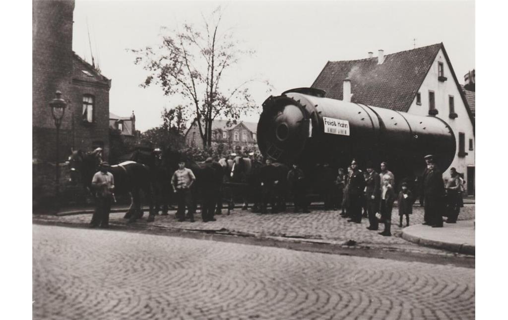 Ein Gespann aus sechs Pferden zieht einen riesigen Dampfkessel, der in der Firma Feld & Hahn in Bendorf gefertigt wurde, in Richtung Sayner Bahnhof (1932-1935).
