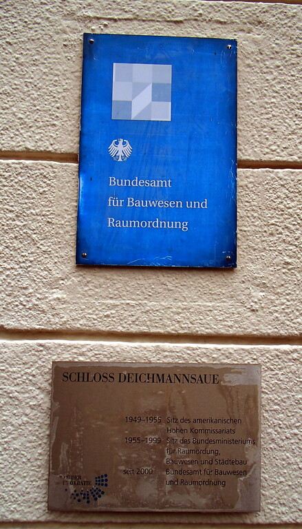 Plaketten neben der Hauptpforte des Schlosses Deichmannsaue in Bonn-Rüngsdorf, die seine Historie von nach dem Krieg bis heute als Sitz des Bundesamts für Bauwesen und Raumordnung kennzeichnen (2020).