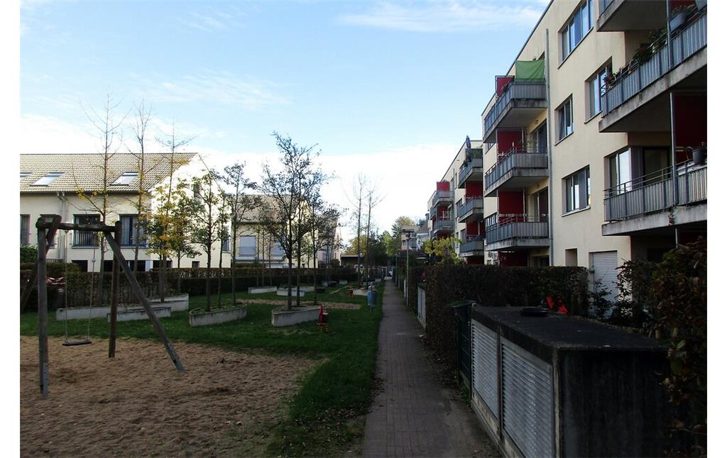 Als Erholungsfläche gestalteter Innenhof der Wohnbebauung am "Preußen-Dellbrück-Weg" in Köln-Dellbrück (2022). Auf dem Gelände der heutigen Wohnsiedlung befand sich einst das Stadion "Et Höffge" des SC Preußen Dellbrück.