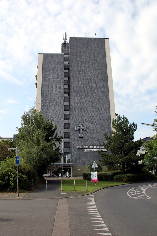 Seitenansicht des höchsten Hochhauses von Köln-Neubrück mit der Beschriftung "Deutschorden Wohnstätte Konrad Adenauer" im Einmündungsbereich der Rober-Schumann-Straße in den Europaring (2015).