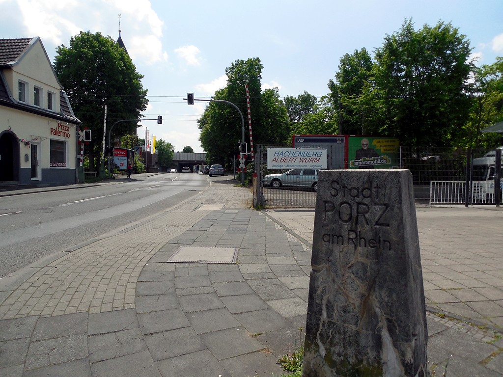 Die Eiler Straße im heutigen Stadtteil Köln-Rath/Heumar im Stadtbezirk Kalk mit Blickrichtung zur Autobahnbrücke der A 3 mit dem Grenzstein der ehemaligen Stadt Porz (2015)