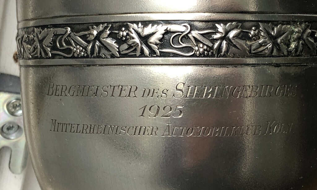 Pokal zum Motorradrennen "Goldener Kranz des Siebengebirges" am 26. April 1925 aus dem Bestand des Siebengebirgsmuseum Königswinter (Inventar-Nr. 2018-FH-0080, Aufnahme 2023). Die Aufschrift lautet: "Bergmeister des Siebengebirge / 1925 / Mittelrheinischer Automobilklub Köln".