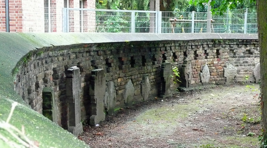 Historische Grabsteine an der Friedhofsmauer auf dem Friedhof in Vilich bei der Stiftskirche Sankt Peter (2014)