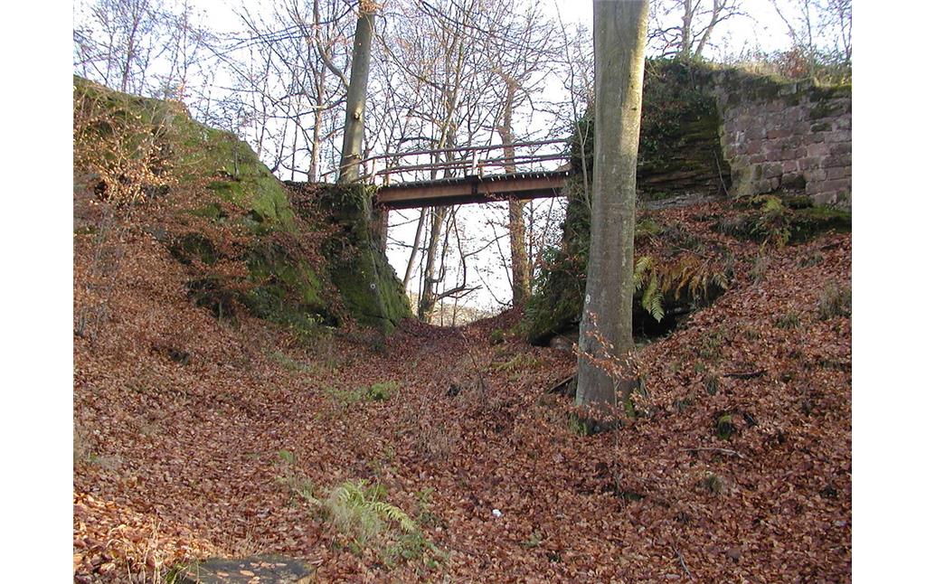 Der Halsgraben der Burg Beilstein bei Kaiserslautern nach dem Jahre 1234. Die Brücke wurde in neuerer Zeit ergänzt (2012).