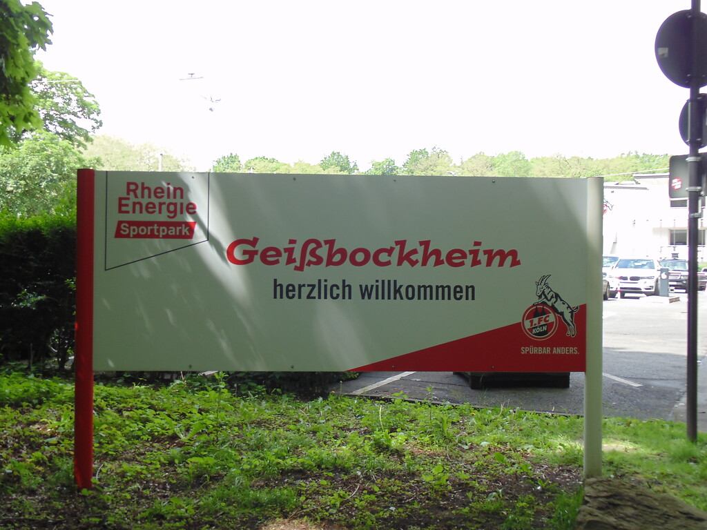 Willkommensschild auf dem Parkplatz des Geißbockheims in Köln-Sülz (2021).