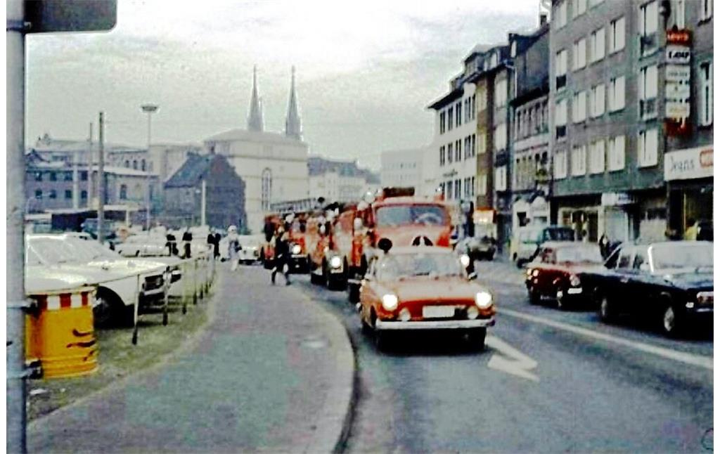 Ein von der Alten Feuerwache ausrückender Löschzug der Bonner Feuerwehr (1969), im Hintergrund sind die JVA Bonn und die Türme der Bonner Stiftskirche St. Johann Baptist und Petrus zu erkennen.