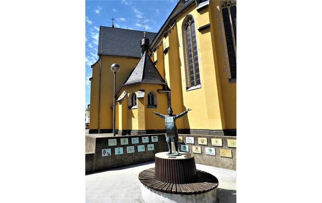 Denkmal für die Karnevalistin und Gastronomin Maria Hollstein in Köln-Porz, das "Fastelovendsplätzchen" mit der Bronzefigur von "Strandbads Marie" befindet sich vor der Pfarrkirche St. Josef (2021).