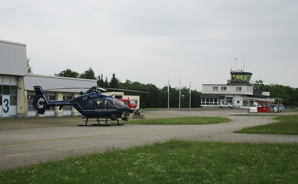Der Flugplatz Koblenz-Winningen ist auch Sitz der Polizeihubschrauberstaffel Rheinland-Pfalz: im Vordergrund ein Hubschrauber der Bundespolizei (Typ Eurocopter EC 135), dahinter der Tower (2016).