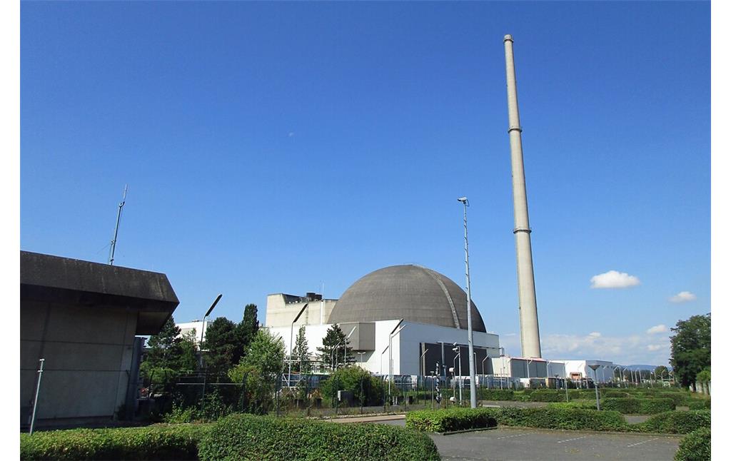 Das stillgelegte Kernkraftwerk Mülheim-Kärlich nach dem 2019 erfolgten Rückbau des Kühlturmes, Ansicht von Westen her auf das kugelförmige Reaktorgebäude und den 161,5 Meter hohen Abluftkamin rechts davon (2020).