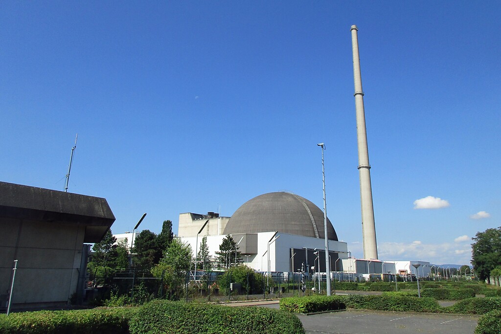 Das stillgelegte Kernkraftwerk Mülheim-Kärlich nach dem 2019 erfolgten Rückbau des Kühlturmes, Ansicht von Westen her auf das kugelförmige Reaktorgebäude und den 161,5 Meter hohen Abluftkamin rechts davon (2020).