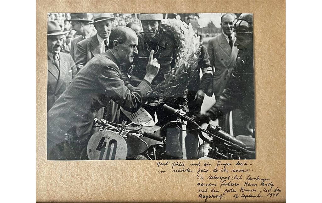 Aufnahme vom Rennen um das Bayerkreuz am 12. September 1948: Der Vorsitzende des ADAC Nordrhein und Vizepräsident des ADAC, Hans Bretz (1897-1976), gratuliert dem Sieger in der Motorrad-Klasse bis 250 ccm, Hans Hoetzer aus Burscheid auf Puch.