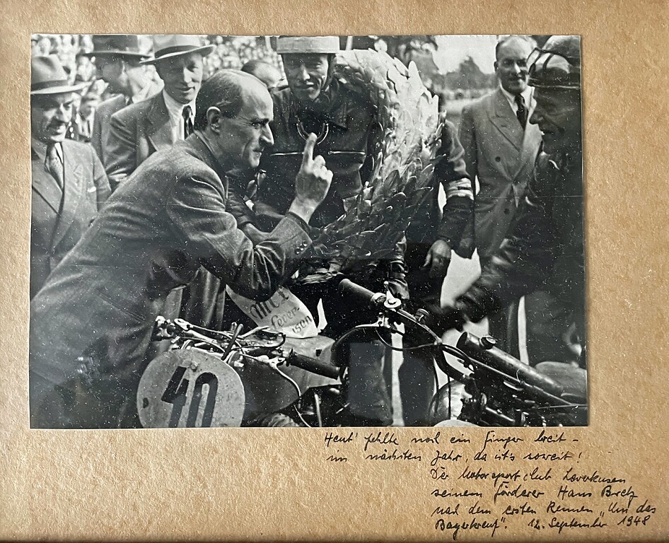 Aufnahme vom Rennen um das Bayerkreuz am 12. September 1948: Der Vorsitzende des ADAC Nordrhein und Vizepräsident des ADAC, Hans Bretz (1897-1976), gratuliert dem Sieger in der Motorrad-Klasse bis 250 ccm, Hans Hoetzer aus Burscheid auf Puch.