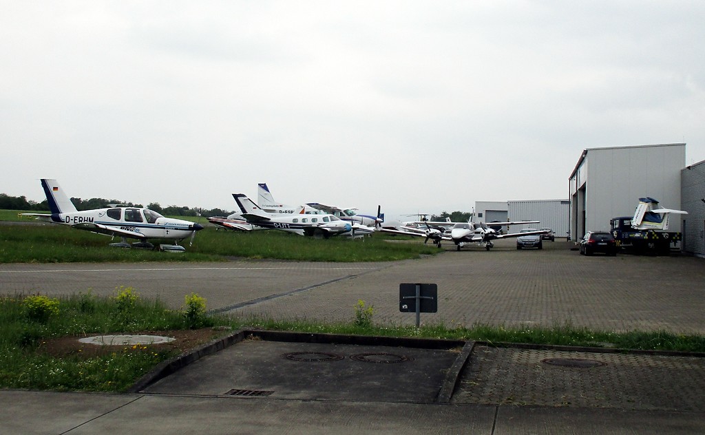 Flugzeugwerft auf dem Flugplatz Koblenz-Winningen, davor mehrere Sportflugzeuge (2016).