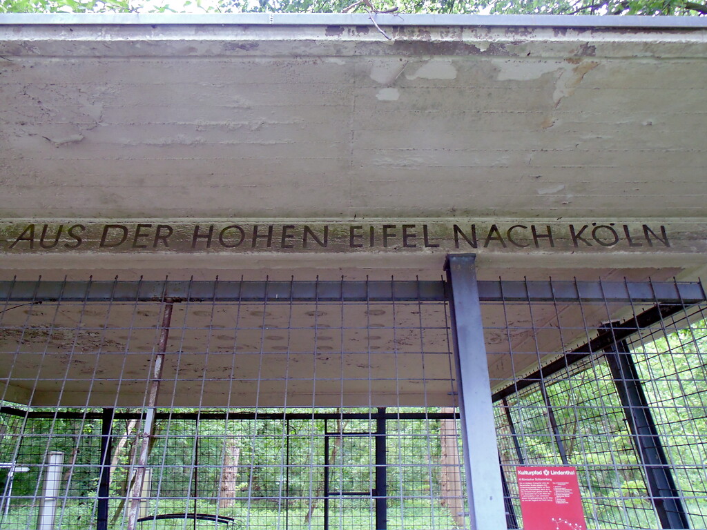 Inschrift (Teil I) am Schutzbau des ehemaligen Absetzbecken der römischen Eifelwasserleitung in Köln-Sülz (2021).