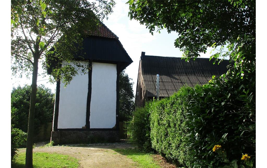 Blick gen Süden auf den Raveshof zur rechten Seite und auf den öffentlich per Fußweg zugänglichen St. Huberter Berfes, ein Turmspeicher mit Wehrfunktion (2017).