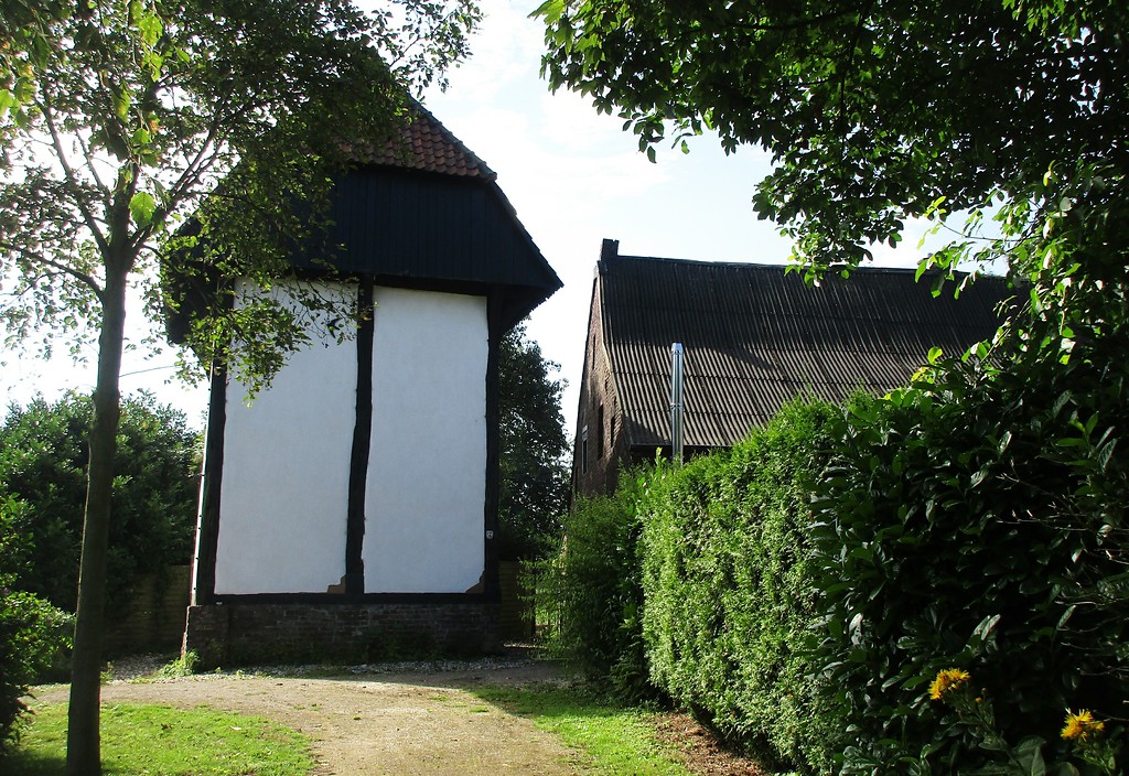Blick gen Süden auf den Raveshof zur rechten Seite und auf den öffentlich per Fußweg zugänglichen St. Huberter Berfes, ein Turmspeicher mit Wehrfunktion (2017).