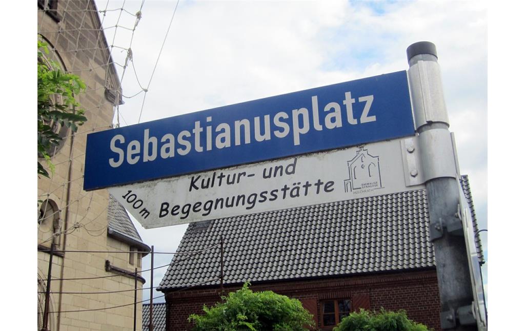 Ein Hinweisschild "Kultur- und Begegnungsstätte" (ehemalige Synagoge) unter der Straßenbezeichnung "Sebastianusplatz" (2014)