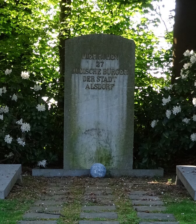 Der Gedenkstein auf dem jüdischen Friedhof Alsdorf auf dem Areal des heutigen Nordfriedhofs (2020). Die Inschrift auf dem Stein lautet: "Hier ruhen 27 jüdische Bürger der Stadt Alsdorf".