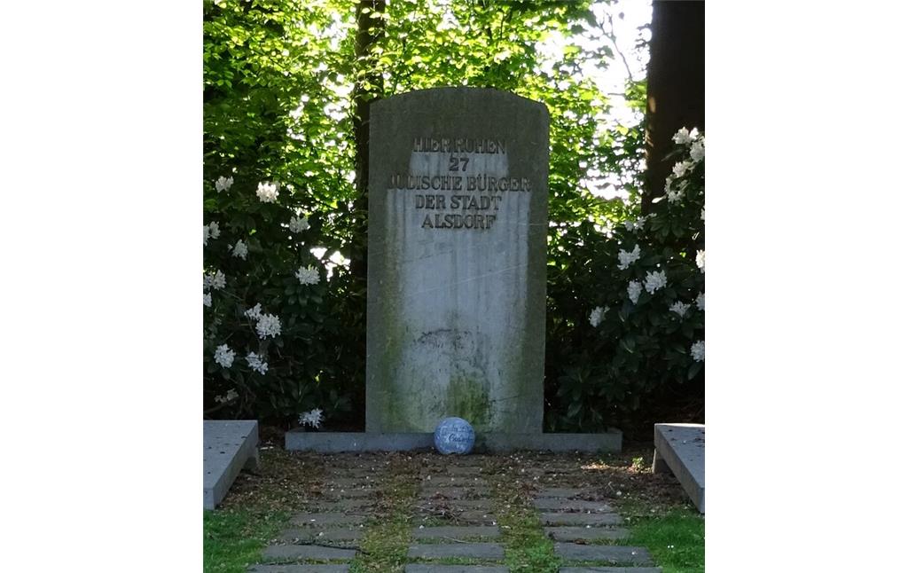 Der Gedenkstein auf dem jüdischen Friedhof Alsdorf auf dem Areal des heutigen Nordfriedhofs (2020). Die Inschrift auf dem Stein lautet: "Hier ruhen 27 jüdische Bürger der Stadt Alsdorf".