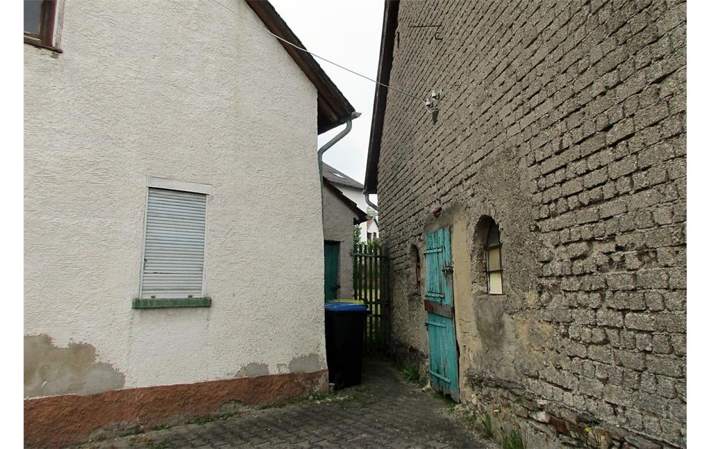 Durchgang zwischen dem Wohnhaus Schlossstraße 3 in Dörrebach und der benachbarten Scheune (2016); hinter den Gebäuden befand sich einst das von der jüdischen Gemeinde als Synagoge bzw. Betstube genutzte Haus, das 1929 wegen Baufälligkeit abgerissen werden musste.