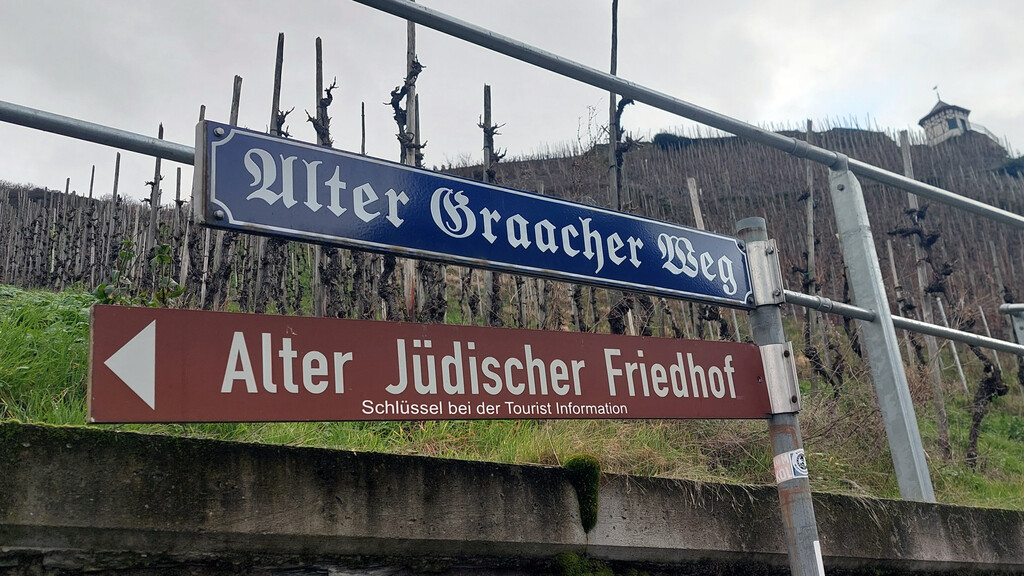 Wegeschild "Alter Graacher Weg" und Hinweisschild in Richtung des jüdischen Friedhofs am nördlichen Ortsausgang von Bernkastel-Kues (2023).