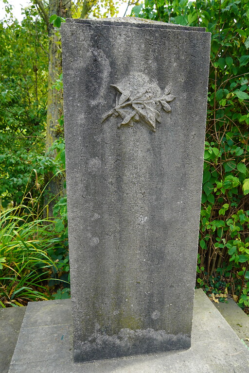 Der Gedenkstein mit dem herausgearbeiteten Soldatenhelm und dem Laubzweig, Teil des Kriegsdenkmals im Stadtwald in Köln-Lindenthal (2021).