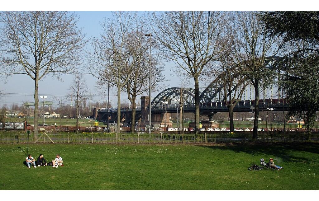 Liegewiese im heutigen Friedenspark im Bereich des einstigen Forts I im Inneren Grüngürtel in Neustadt-Süd, im Hintergrund die Südbrücke über den Rhein (2022).
