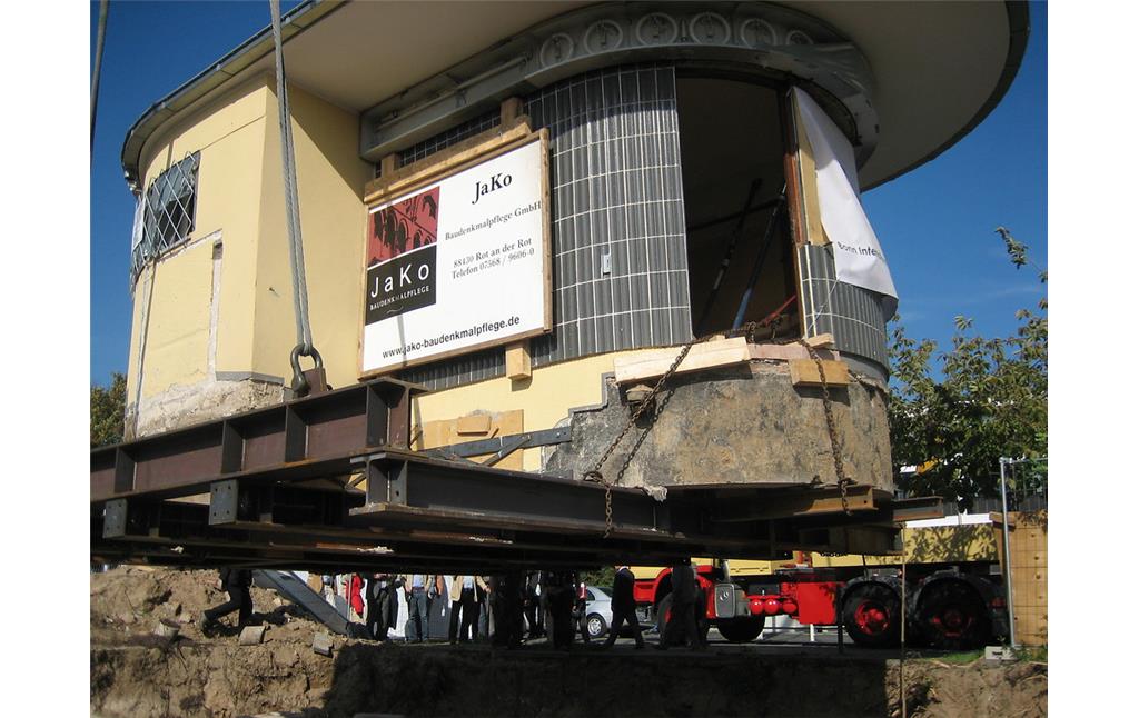 Ein Kran hebt das denkmalgeschützte "Bundesbüdchen", einen Kiosk im Bonner Regierungsviertel an, um diesen zu seinem Zwischenlager, einem Bauhof in Hersel, transportieren zu können (2006).