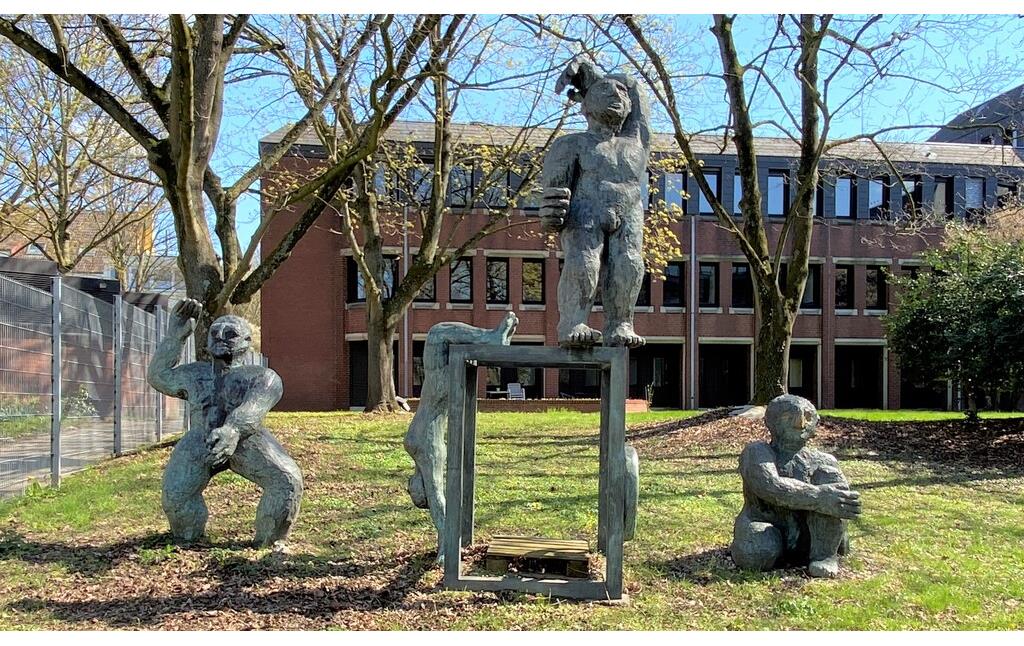 Frontalansicht der Skulpturengruppe "Menschen am Tresor" von Klaus Kampert im Rathauspark in Köln-Porz (2023).