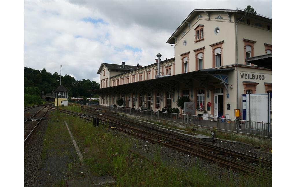 Hauptgebäude des Bahnhofs Weilburg mit Bahnsteig und Gleisanlagen im Vordergrund (2017)