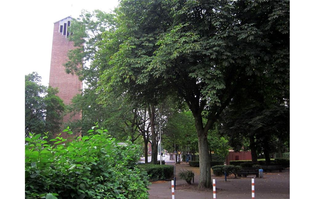 Die Backsteinplastik "Huset" (rechts im Bild) und die gegenüber liegende Heilig-Geist-Kirche in Frechen-Bachem (2013).
