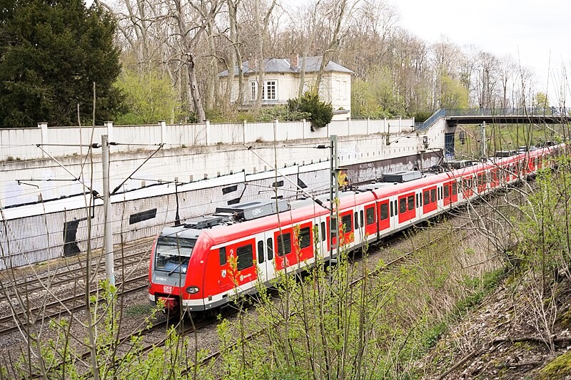 Der Bahnhof Belvedere in Köln-Müngersdorf mit Regionalbahn im Vordergrund (2021)