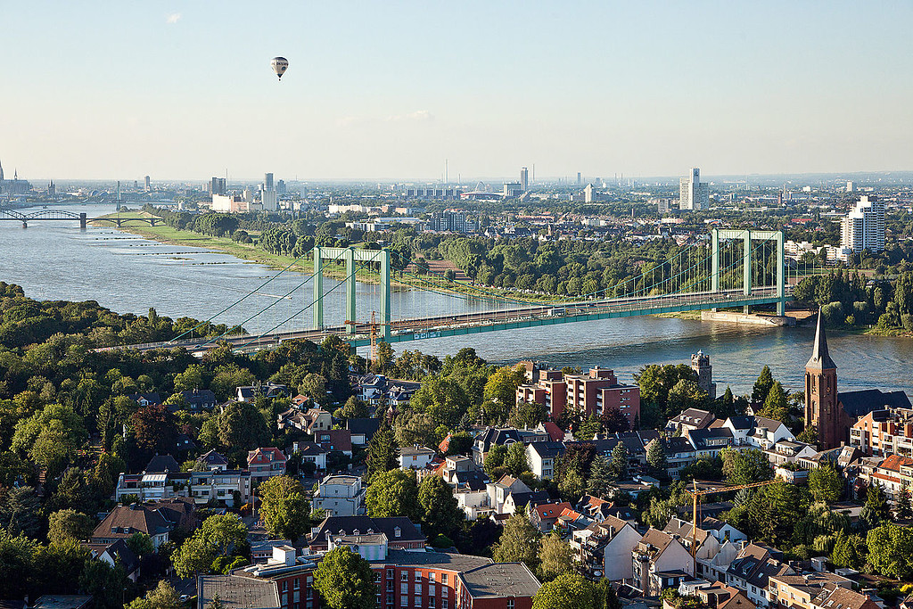 Luftbild mit der Rodenkirchener Rheinbrücke im Süden von Köln (2010). Im Vordergrund ist der Kölner Stadtteil Rodenkirchen und im Hintergrund der Stadtteil Deutz zu sehen.