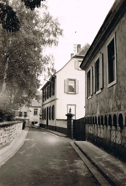 Historische Aufnahme des ehemaligen fürstbischöflichen Wachthauses (vorne) und des barocken Pfarrhauses (hinten) in der Kirschstraße in Kirrweiler (1960er Jahre)