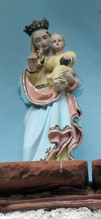 Muttergottes-mit-Kind-Figur in der Nische über dem gotischen Eingangsbogen