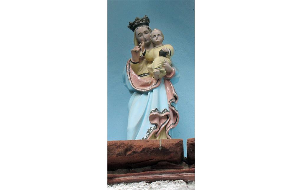 Muttergottes-mit-Kind-Figur in der Nische über dem gotischen Eingangsbogen