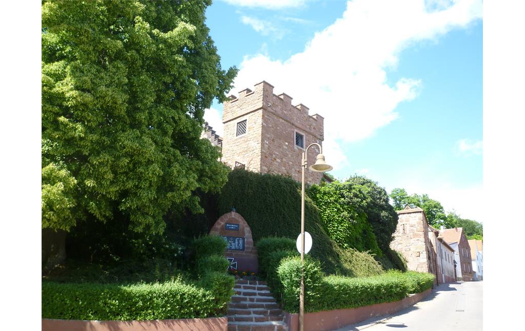 Südwestansicht des Glockenturms von Stauf. Im Vordergrund ist ein Weltkriegsdenkmal am Straßenrand zu sehen (2011).