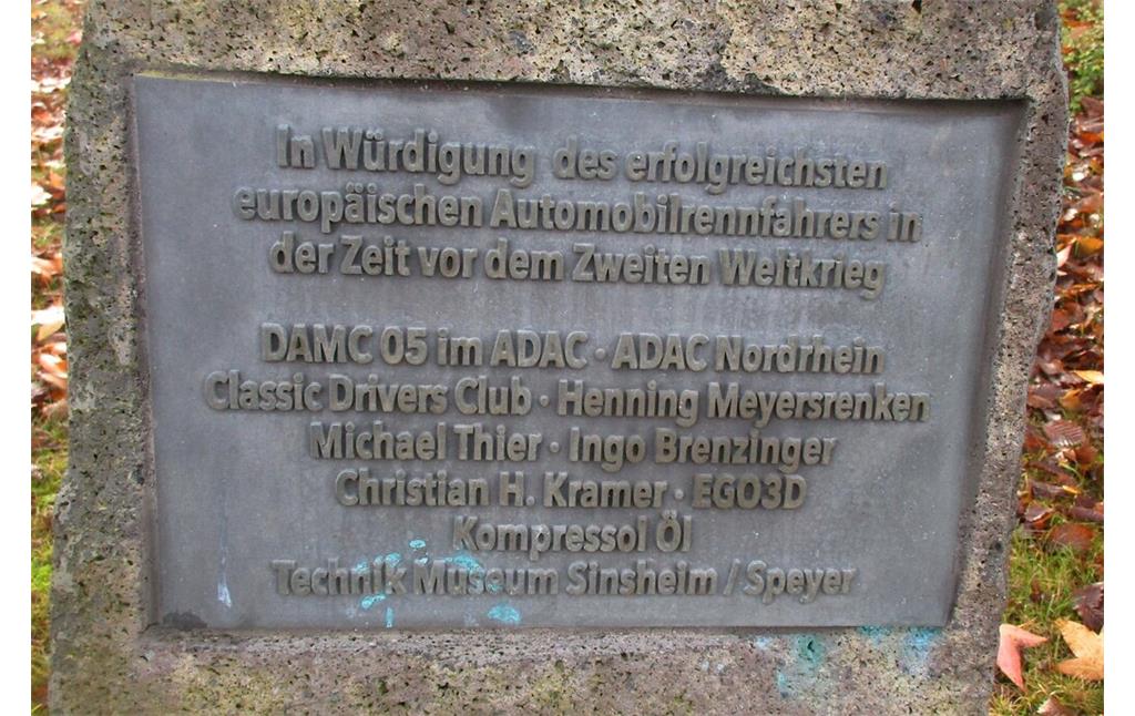 Die untere der beiden Inschriftentafeln am Caracciola-Denkmal am Nürburgring würdigt den Rennfahrer Rudolf Caracciola (1901-1959) als "erfolgreichsten europäischen Automobilrennfahrer in der Zeit vor dem Zweiten Weltkrieg" (2020).