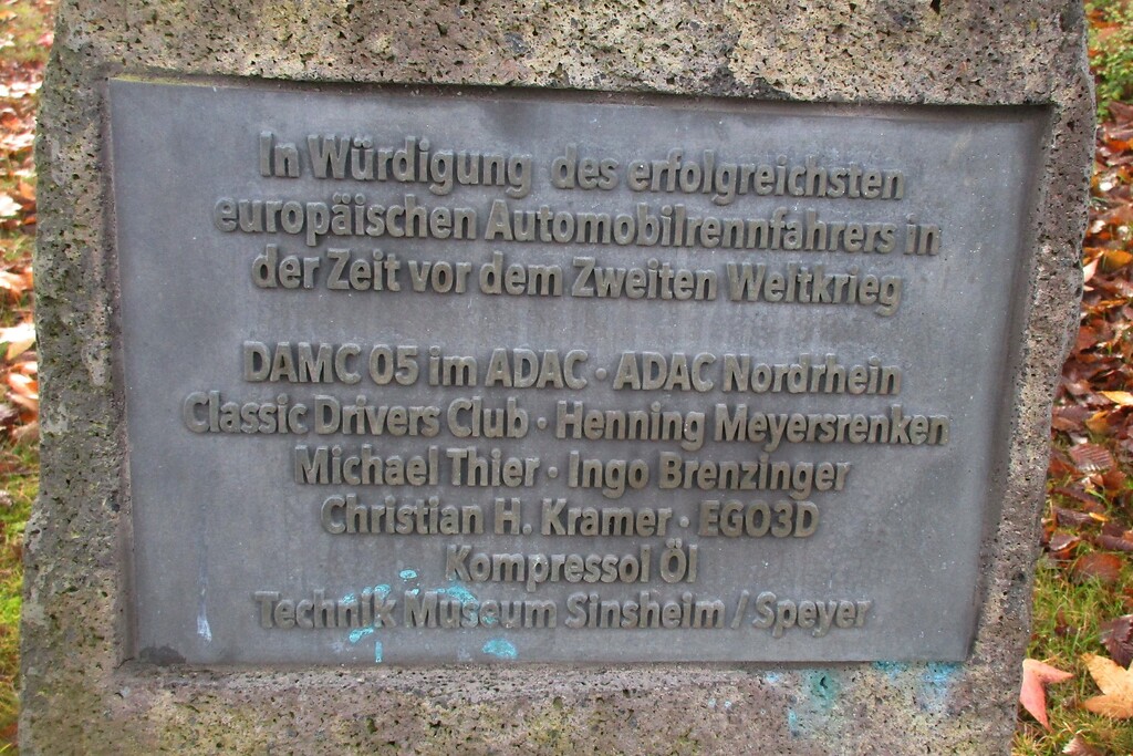 Die untere der beiden Inschriftentafeln am Caracciola-Denkmal am Nürburgring würdigt den Rennfahrer Rudolf Caracciola (1901-1959) als "erfolgreichsten europäischen Automobilrennfahrer in der Zeit vor dem Zweiten Weltkrieg" (2020).