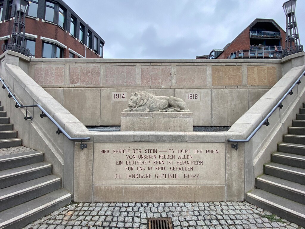 Die repräsentative Treppenanlage am Porzer Rheinufer mit dem zentralen Löwenmonument, das an die gefallenen Porzer des Ersten Weltkrieges erinnert. Im Hintergrund ist links der Anbau des Porzer Rathauses zu erkennen (2023).