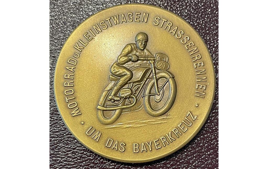 Teilnahmeplakette für das "Motorrad u. Kleinstwagen Strassenrennen um das Bayerkreuz" im Jahr 1949. Die Vorderseite zeigt ein zeitgenössisches Rennmotorrad.